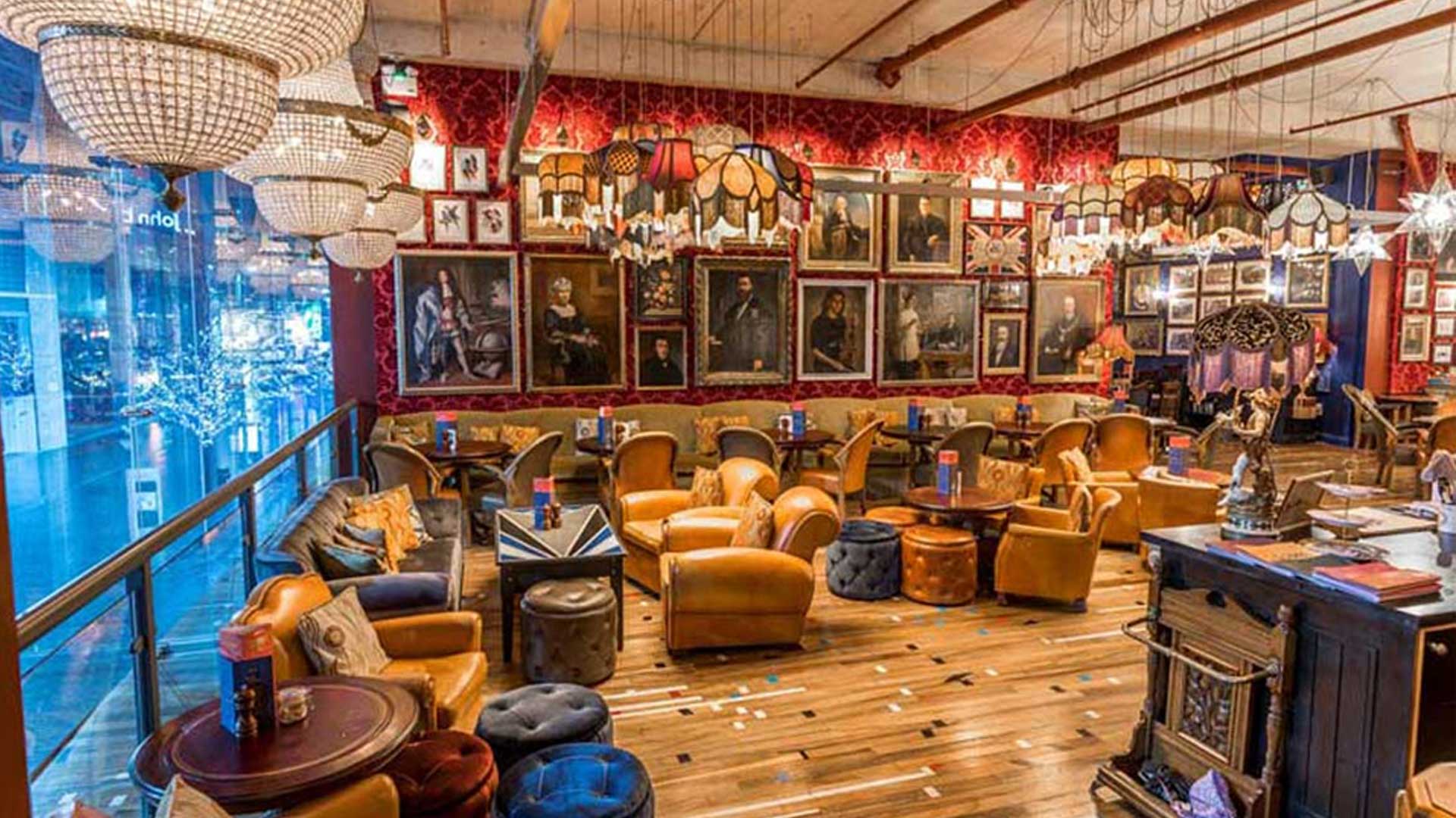 Eclectic vintage-style bar lounge area with portrait gallery.
